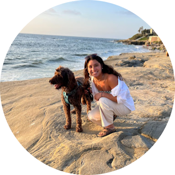 Student next to a dog on the beach